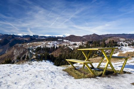 Yellow bench in front of a beautiful mountain landscapeの写真素材