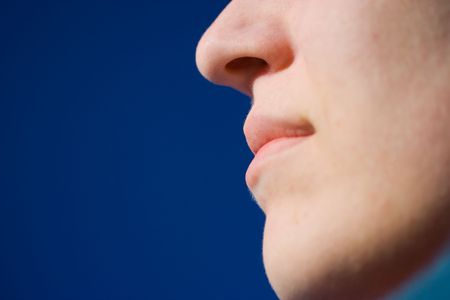 Lips and nose over blue sky backgroundの写真素材