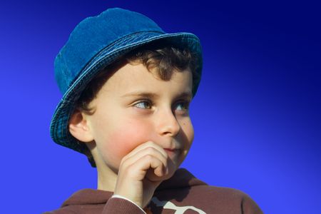 Close-up portrait of a beautiful boy thinking under clear blue skyの写真素材