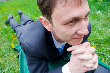 Businessman working outdoors in a meadow with dandelionsの写真素材