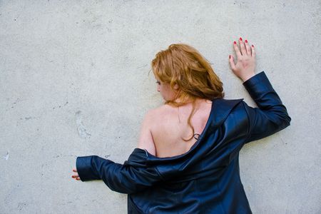 Portrait of an abused blond woman near a wallの写真素材