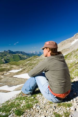 Portrait of a young woman admiring the beautiful view of Alpsの写真素材