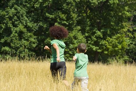 Mother playing with her son in a meadow, in a sunny dayの写真素材