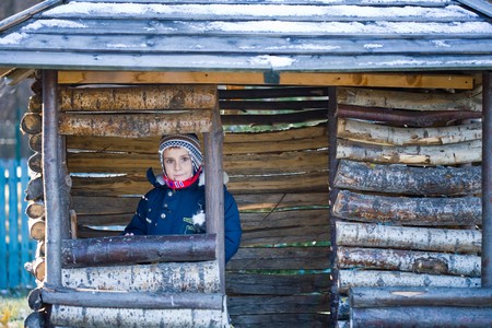 Cute 7 year old kid playing in a small wooden houseの写真素材