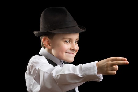 Portrait of a gorgeous little boy posing as a gangster, isolated on blackの写真素材