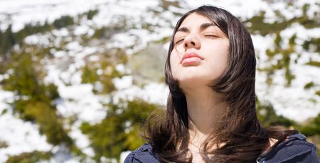 Pretty brunette girl outdoor in a spring day, when the snow is meltingの写真素材
