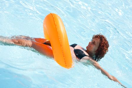 Woman swimming with a rubber ring in a hotel pool