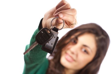 Young saleswoman handing over car keys, isolated on white backgroundの写真素材