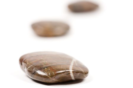 Close-up of shiny brown zen stones isolated on white backgroundの写真素材