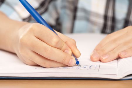 Close up of a hand of a pupil writing homework or examination