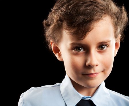 Portrait of a cute schoolboy isolated on black background