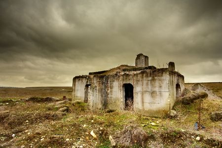 Landscape with a decrepit ruin of a building under moody skyの写真素材