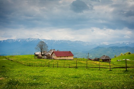 Landscape with a house on a grassland under sky with cloudsの写真素材