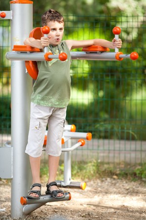 Kid with cool haircut doing fitness outdoor and having funの写真素材
