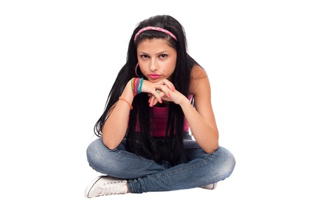 Portrait of a beautiful teenager sitting, isolated on white backgroundの写真素材