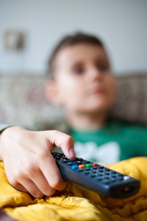 Child watching tv, holding remote control - shallow depth of fieldの写真素材