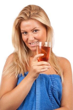 Attractive blonde woman in blue towel having a cold drinkの写真素材