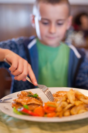 Portrait of a child having lunch in a restaurantの写真素材