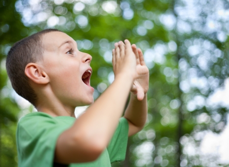 Close up portrait of a kid yelling into the forestの写真素材