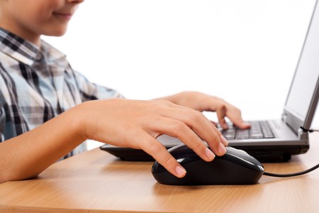 Close up of a schoolboy's hands using mouse and keyboardの写真素材