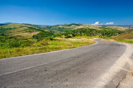 Alpine landscape with a road going to a villageの写真素材