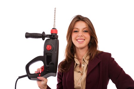 Young businesswoman in suit wielding a pneumatic hammer, conceptual imageの写真素材