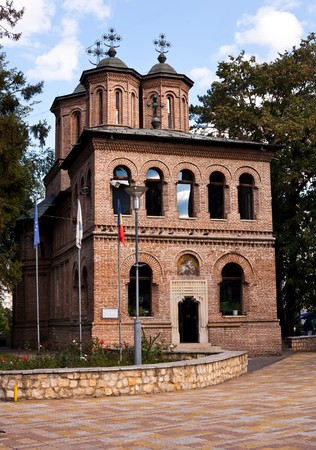 Red brick church among trees with blue sky in backgroundの写真素材