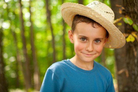 Portrait of a funny kid with straw hat outdoorの写真素材