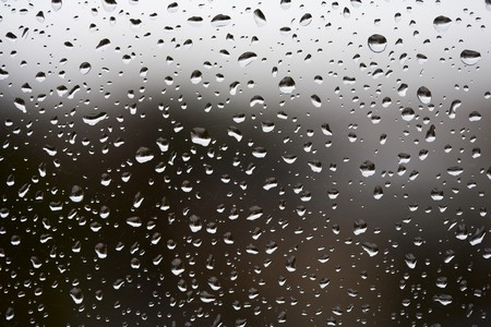 Macro of rain drops of a window with blurred backgroundの写真素材