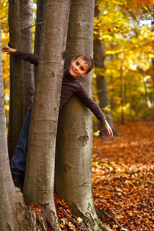 Cute kid playing outdoor in a beautiful autumn dayの写真素材