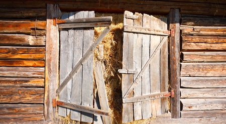 Door of a traditional Romanian barn or shack, full of hayの写真素材