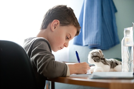 Portrait of a schoolboy doing homework at his deskの写真素材