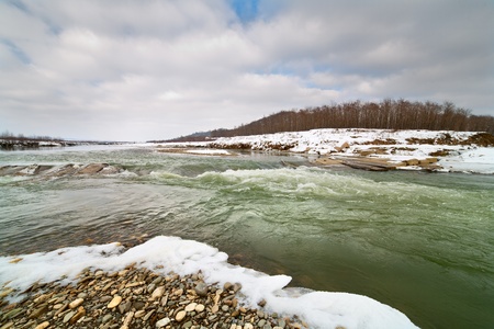 Winter landscape with a river in a cloudy dayの写真素材