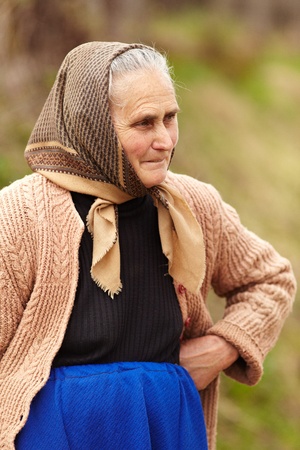 Portrait of an old rural woman with kerchief over blurred backgroundの写真素材