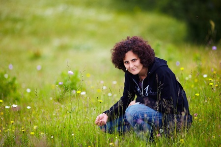 Portrait of a young attractive redhead woman with curly hair outdoorの写真素材