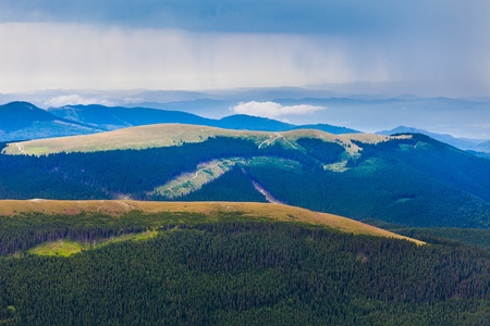Landscape of Parang mountains in Romania, in summer with a heavy rain in the distanceの写真素材