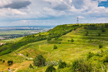 Landscape of a hill with meadows and a town nearbyの写真素材