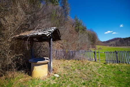 Rural landscape with an antique wooden well near the forestの写真素材