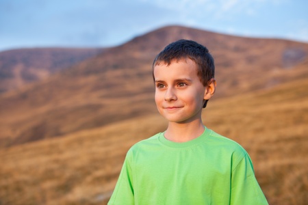 Portrait of a cute boy on Parang mountains, Romania, at sunsetの写真素材