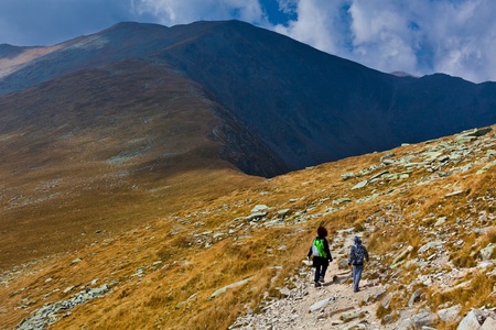Mother and son hiking into the mountains, in the eveningの写真素材