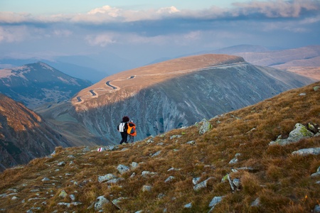 Mother and son hiking into the mountains, in the eveningの写真素材