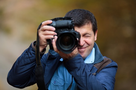 Professional nature photographer taking photos in the forest in an autumn dayの写真素材