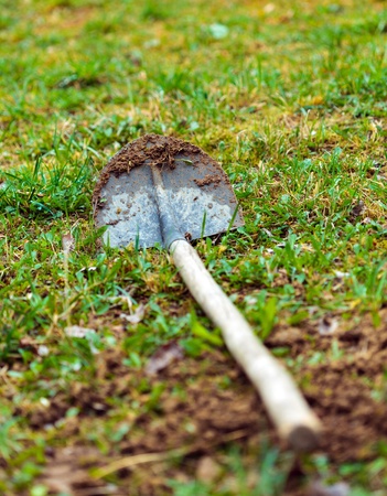 Dirty shovel in grass with selective focus