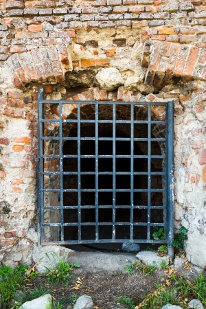 Ancient brick wall with gratesの写真素材