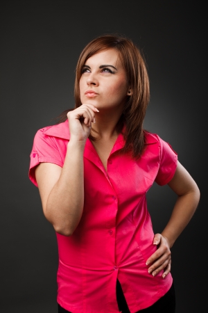 Studio portrait of a thoughtful young businesswoman over gray backgroundの写真素材