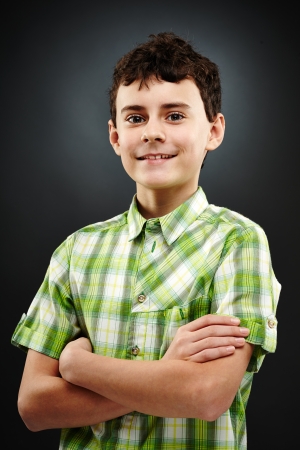 Closeup portrait of a teen boy in plaid shirt with his arms foldedの写真素材