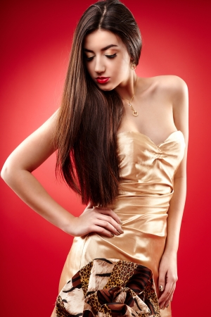 Portrait of a beautiful woman posing on red backgroundの写真素材