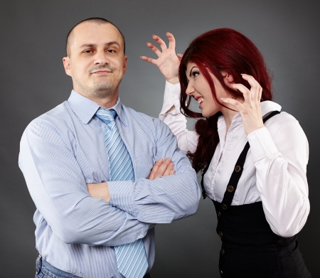 Portrait of a businessman ignoring angry businesswomanの写真素材