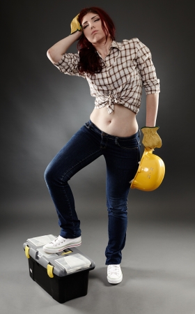 Over worked construction lady, full length on gray backgroundの写真素材