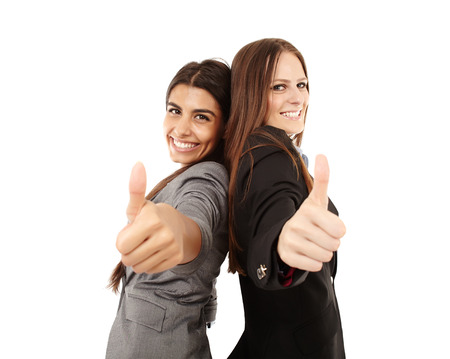 Portrait of businesswomen making thumbs up sign and smiling over white backgroundの写真素材